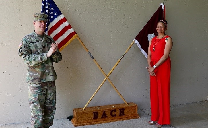 Image of Soldier and woman standing by two flags, crossed. Click to open a larger version of the image.