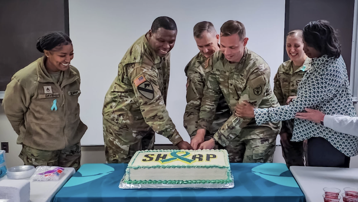 Military personnel cut cake to kick off Sexual Assault Awareness and Prevention Month