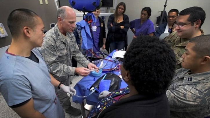 Military personnel sitting around a table, exhibiting medical items