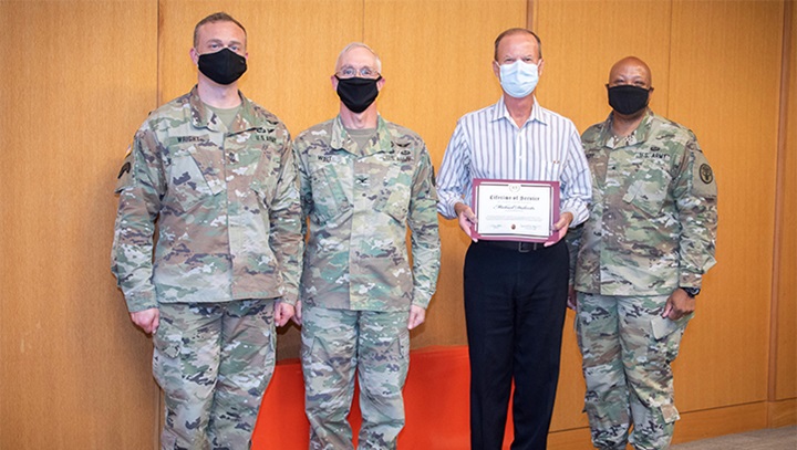 Image of Military personnel wearing face masks posing for a picture.