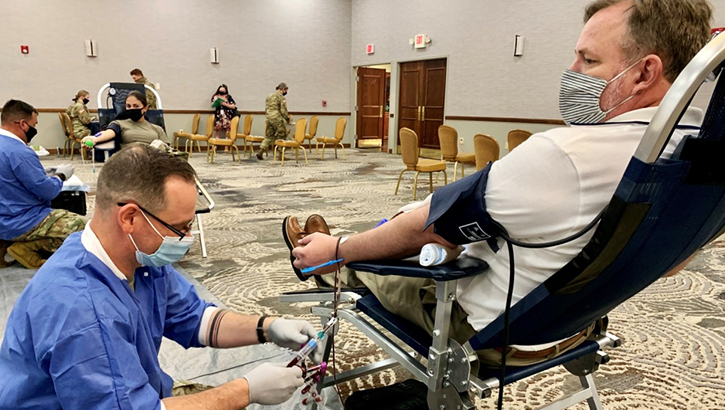 Image of Man wearing mask, giving blood. Click to open a larger version of the image.