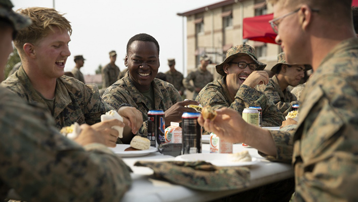 Picture of military personnel sitting at a table eating food together