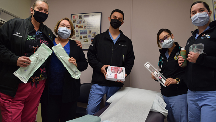 Image of Five people wearing masks look at the camera.