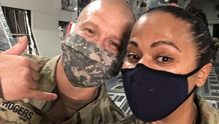Image of Military personnel wearing face mask posing for a picture.