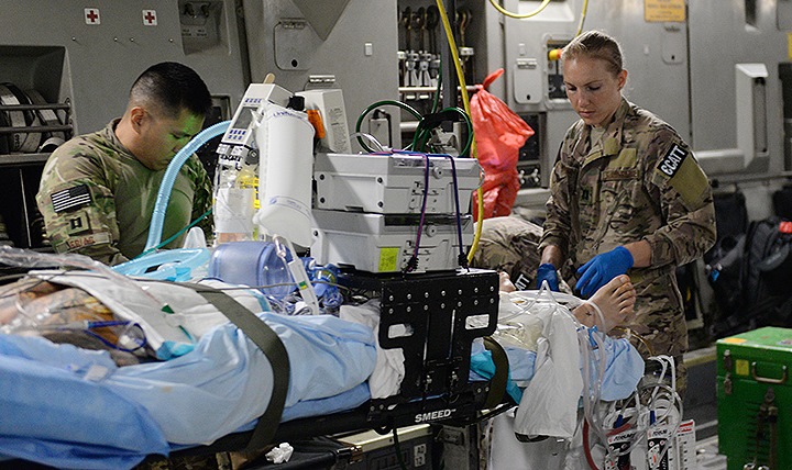 Air Force Capt. Deann Hoelscher (right), 455th Expeditionary Aeromedical Evacuation Squadron Critical Care Air Transport Team physician deployed from the 60th Medical Group at Travis Air Force Base, California, and U.S. Capt. Jason Frias, 455th EAES CCATT critical care nurse, also deployed from the 60th Medical Group at Travis AFB, ensure a patient is properly secured prior to an aeromedical evacuation mission aboard a C-17 Globemaster III aircraft from Bagram Airfield, Afghanistan, to Ramstein Air Base, Germany. (U.S. Air Force photo by Maj. Tony Wickman)