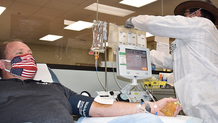 Image of man wearing mask and giving blood. Click to open a larger version of the image.