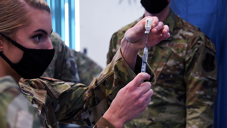 Image of Military personnel administering the COVID-19 vaccine. Click to open a larger version of the image.