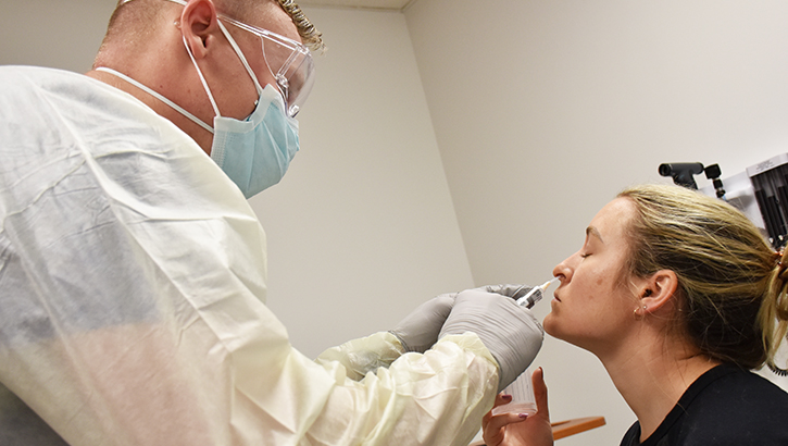 Image of technician taking a nasal swab of a patient