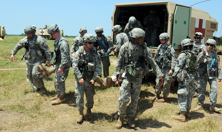 Army medics with Company C, 106th Support Battalion, 155th Armored Brigade Combat Team, carry a litter patient from the ambulance to the Troop Medical Clinic while participating in a mass casualty event during an Exportable Combat Training Capability exercise at Camp Shelby Joint Forces Training Center. (U.S. Army photo by Staff Sgt. Scott Tynes)