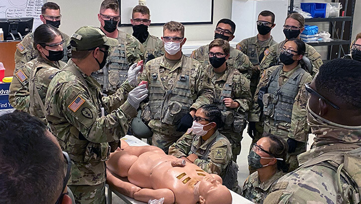A soldier provides instruction on advanced airway management on a simulated trauma patient.