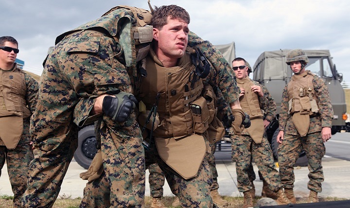 Navy Petty Officer 3rd Class Dustin McCann shows Marines the proper technique for a fireman’s carry during a casualty evacuation exercise