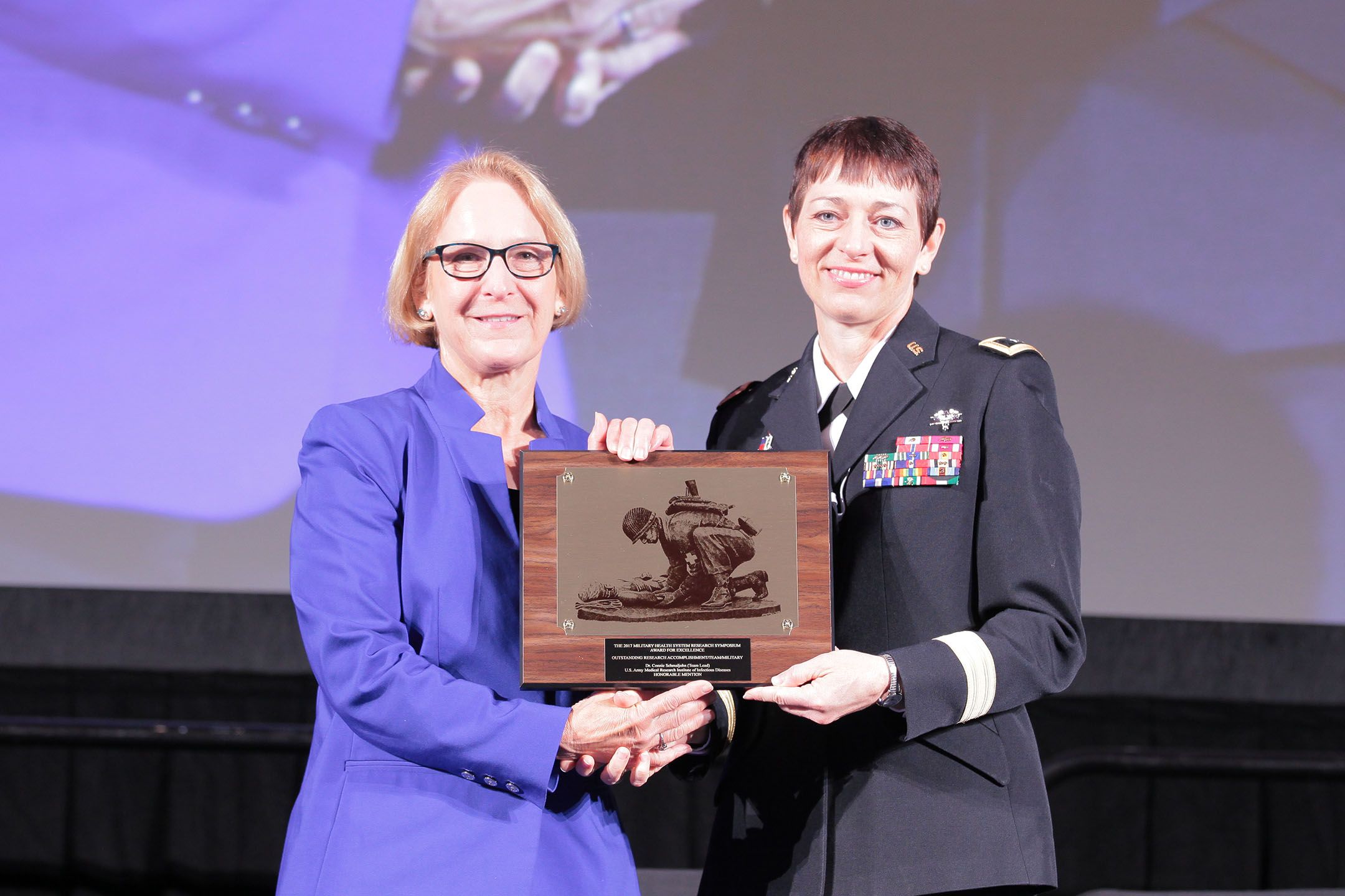 Major General Barbara R. Holcomb, commanding general of the U.S. Army Medical Research and Materiel Command, presented Connie S. Schmaljohn, Ph.D. and her team of military and civilian scientists from the U.S. Army Medical Research Institute of Infectious Disease the 2017 Team Research Accomplishment (Military), in the category of Infectious Disease, on Aug. 28 at the Military Health System (MHS) Research Symposium. The team received honorable mention for the successful development and human clinical testing of a state-of-the-art DNA vaccine to prevent hemorrhagic fever with renal syndrome. 