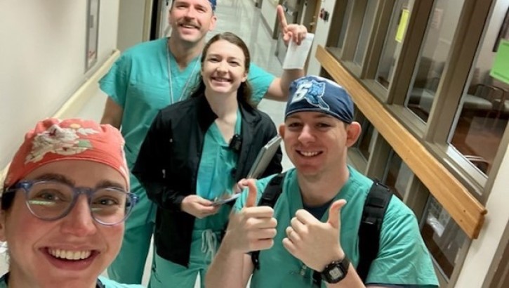 A group of smiling Otolaryngology residents pose in a hallway. 