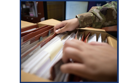 Military personnel thumbing through files