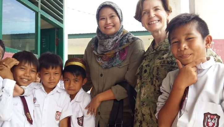 Cmdr. Mojica poses with an Indonesian teacher and school children during a visit to SD 83 Elementary as a part of Pacific Partnership 2018 (PP18), Apr. 5, 2018. PP18’s mission is to work collectively with host and partner nations to enhance regional interoperability and disaster response capabilities, increase stability and security in the region, and foster new and enduring friendships across the Indo-Pacific Region. (U.S. Navy courtesy photo)