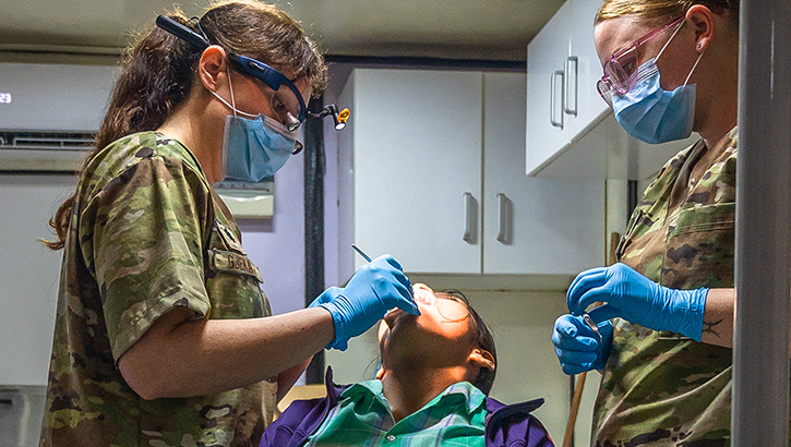 U.S. Air Force Lt. Col. Susan Gjekaj, Air Expeditionary Squadron pediatric dentist, operates on a student of the Johan Chelius School in Redi Doti, Suriname, on Feb. 13. Dental personnel from the Lesser Antilles Medical Assistance Team engaged with members in the Lokono and Kalin'a villages to provide extractions, fillings, cleanings and teach best practices for sustaining good oral hygiene. (U.S. Air Force Senior Airman Alexus Wilcox) 