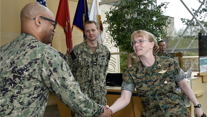 U.S. Navy Rear Adm. Pamela Miller shakes hands with acting Command Master Chief David Green