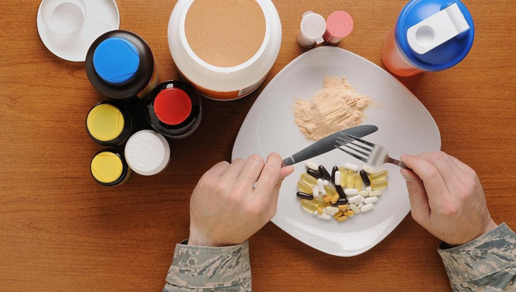 Image of Photo of a dinner plate with food and dietary supplements next to it.