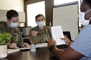 Military health personnel wearing face masks receiving instructions