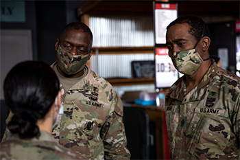 Military personnel wearing face mask talking