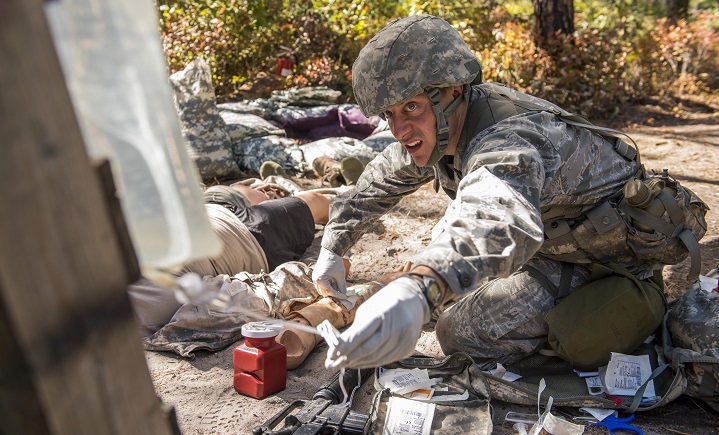 Air Force Capt. Richard Pate, a Walter Reed National Military Medical Center nurse, checks an IV for a simulated patient during an Expert Field Medical Badge competition at Joint Base McGuire-Dix-Lakehurst, N.J. The competition candidates had to run through a tactical combat care course while evading simulated attacks and attending to patients. (U.S. Air Force photo by Senior Airman Tara A. Williamson)
