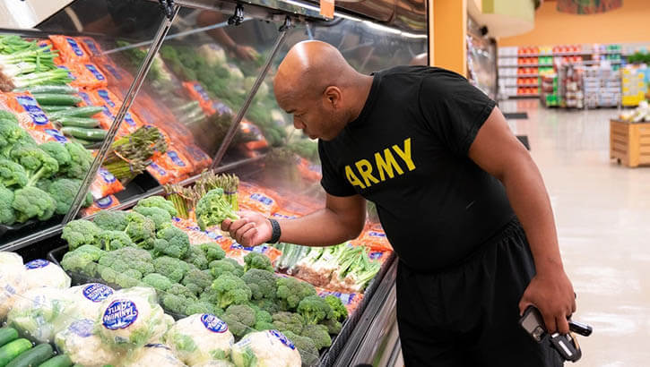 Image of Military personnel picking out broccoli. Click to open a larger version of the image.