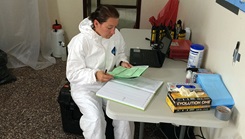 U.S. Navy Lt. Andrea McCoy reviews specimen documentation and recording data in laboratory log-book at a Naval Medical Research Center mobile laboratory at Bushrod Island, Liberia. 
