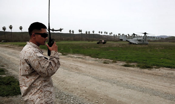 A data network specialist from Headquarters Regiment, 1st Marine Logistics Group, communicates with an MV-22 Osprey pilot during an en-route care exercise aboard Camp Pendleton, Calif., Jan. 28, 2015. During the four-day exercise, corpsmen trained to prepare a Special-Purpose Marine Air-Ground Task Force group that is going to forward deploy later this year. The more than 40 corpsmen set up a shock trauma platoon facility, or mobile emergency room, to treat simulated casualties. The casualties were stabilized in the STP and then flown out via aircraft. (U.S. Marine Corps photo by Sgt. Laura Gauna/Released) 