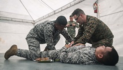U.S. Navy Lt. Terrence Hamilton, right, a medical physician assigned to Marine Rotational Force-Southeast Asia, I Marine Expeditionary Force, and Philippine Coast Guardsmen Seaman Second Class Jerome Devero, apply bandages to a simulated wound during a tactical combat casualty care 
