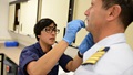 A Coast Guard petty officer administers the intranasal flu vaccine to a Coast Guard member.