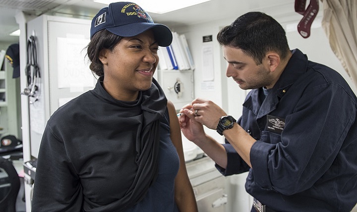 Operations Specialist 2nd Class D'Lorah Pierce, from Washington, N.C. (left), receives a flu shot from Hospital Corpsman 1st Class German Cea, from Sacramento, Calif., aboard the guided-missile destroyer USS William P. Lawrence. 