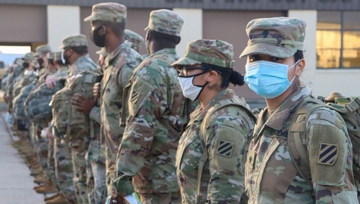 Image of Soldiers standing in a line, wearing masks.