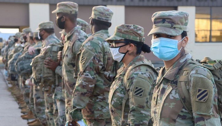 Soldiers standing in a line, wearing masks
