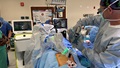Military medical personnel performing spinal surgery