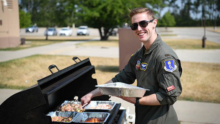 Image of Military personnel grilling food .
