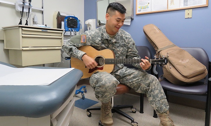 Army Capt. Edwin Choi, a family medicine resident, plays his guitar on occasion to comfort patients. 