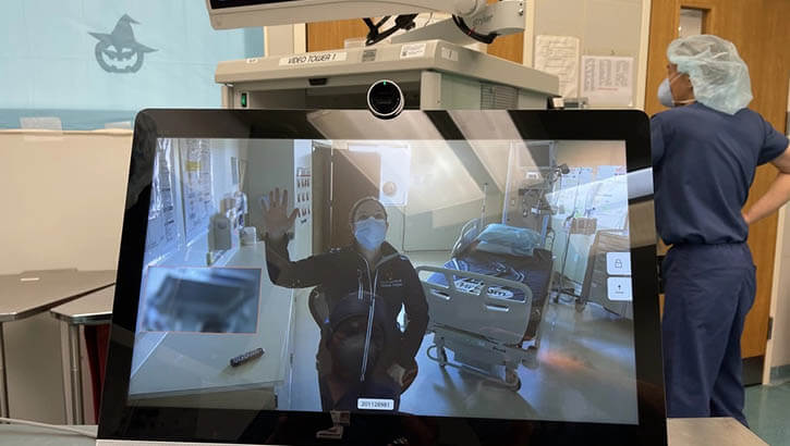 Navy Lt. Cmdr. Kathryn Lipscomb, the urology department head at U.S. Naval Hospital Rota in Spain, waves to staff in USNH Naples, Italy during the first virtual cystoscopy between both hospitals in Jan 2021. (Photo: Navy Cmdr. Ryan Nations)