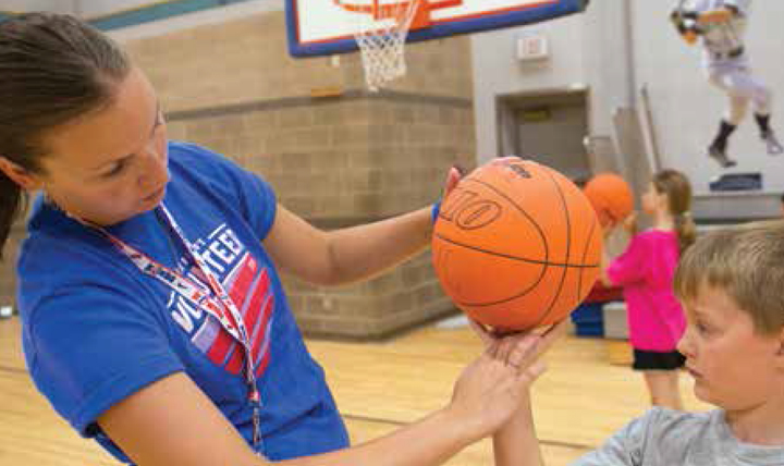 The 366th Force Support Squadron Youth Center Sports and Fitness Director Erin Arel helps a child improve his bank shot July 15, 2014, at Mountain Home AFB, Idaho, one of 14 DoD installations participating in the Healthy Base Initiative (HBI).