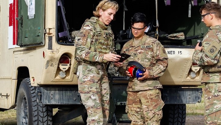 Image of three soldiers looking at an iPad