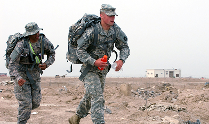 Two U.S. service members perform duties in warm weather where they may be exposed to extreme heat conditions and a higher risk of heat illness.