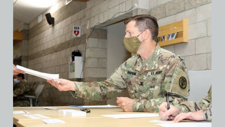 Army Col. Richard Hopkins, the COVID-19 response coordinator with Weed Army Community Hospital, collects paperwork from a Soldier who received the COVID-19 vaccine at a vaccination event.