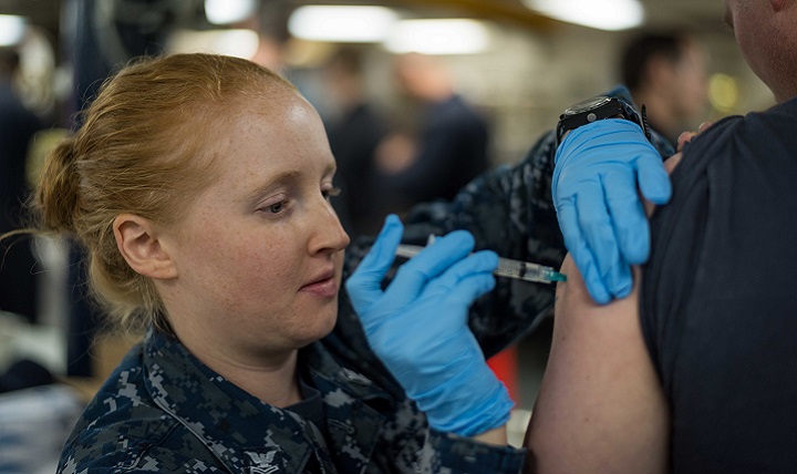 Navy Hospital Corpsman 2nd Class Carly Marcum, administers an influenza vaccination to a Sailor aboard USS John C. Stennis. This flu season, the DoD’s entire supply of flu vaccine will be injectable. (U.S. Navy photo by Mass Communication Specialist Seaman Cole C. Pielop)