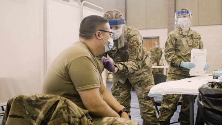 Image of Soldier getting a vaccine in his left arm.