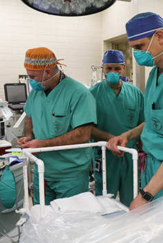 Three surgeons in hospital room wearing masks
