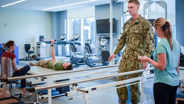 Image of Military health personnel in physical therapy. Click to open a larger version of the image.