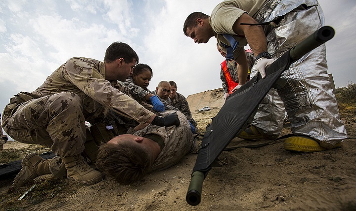 Navy and Air Force medical personnel load a simulated casualty onto a stretcher during a mass casualty exercise at an undisclosed location in Southwest Asia.