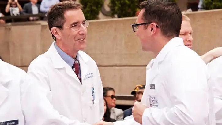 Two men in white medical coats shaking hands