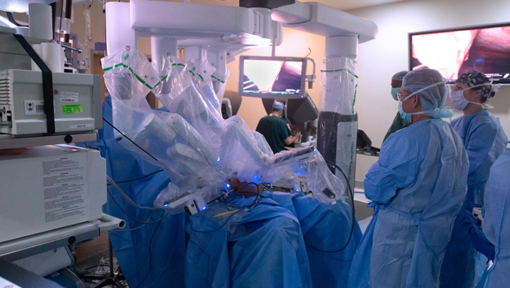 Military medical personnel in an operating room, wearing full PPE