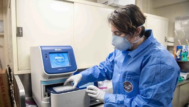 Woman in lab wearing mask and testing samples