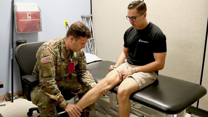 Military health personnel checking out an injury